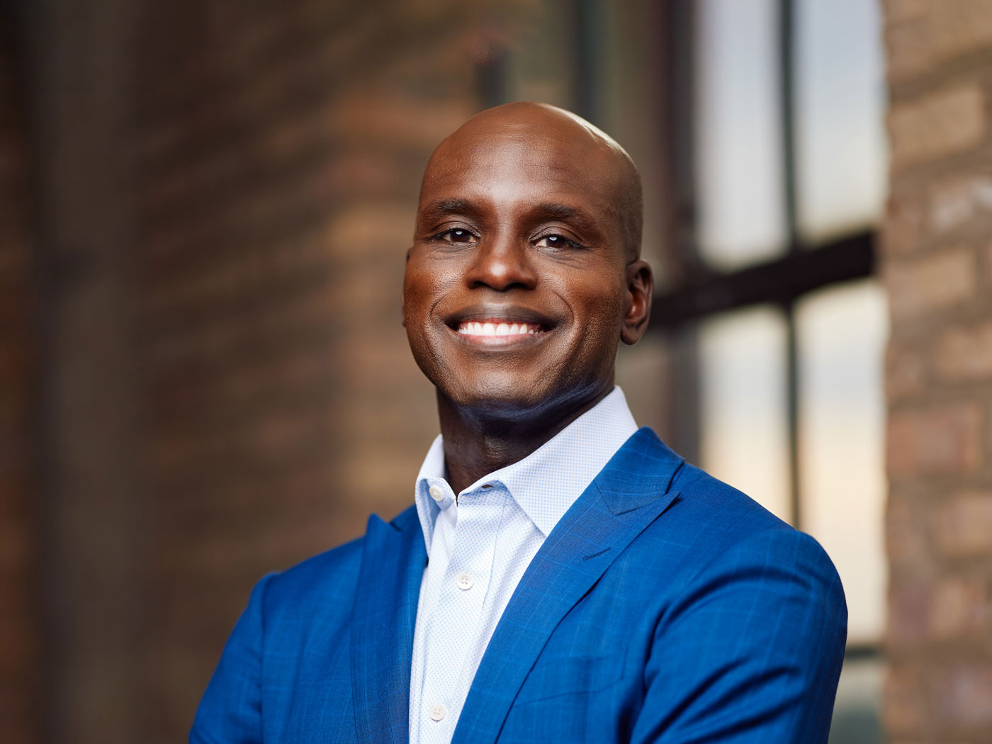 Portrait photo of a man wearning a blue suit and smiling at the camera