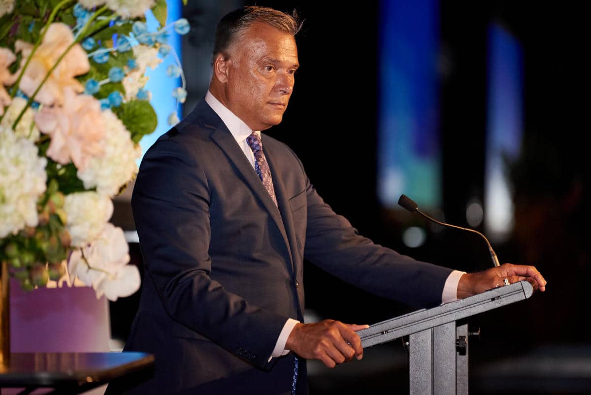 Picture of a man wearing a suit and standing in front of a pulpit